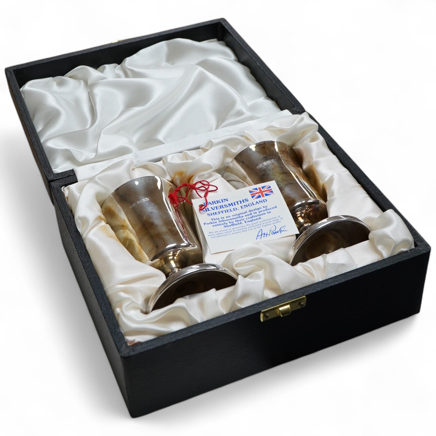 A cased pair of silver pedestal goblets, by Parkinson Silversmiths Ltd, Sheffield, 1984, height 10.6cm, 5.5oz, the case with engraved presentation plaque.